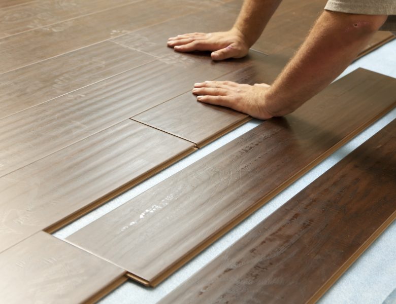 Man Installing New Laminate Wood Flooring Abstract.